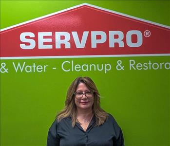 Woman standing in front of green and orange SERVPRO sign